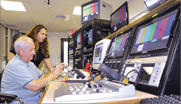 Gloria Enloe watches as Dan Yeager solders a cable at the JCTV studio at Lincoln University. The station has recently begun posting programming on YouTube. Stephen Brooks/News Tribune 