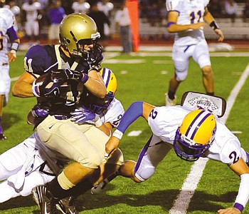 Jordan Colonius of Helias is brought down by a pair of Francis Howell defenders during a game earlier this season at Adkins Stadium. Colonius had two receptions for 119 yards and a touchdown in last week's 39-19 win at Warrensburg.