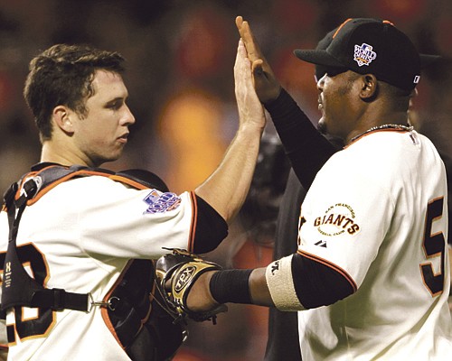 Giants teammates Buster Posey (left) and Juan Uribe celebrate after Wednesday night's win over the Rangers in San Francisco. 