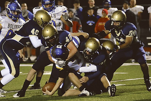 Helias' Zack Steck (42) locks up Bolivar quarterback Kolton Peavy as the Crusaders' Cam Berendzen (40) closes in on the play during Thursday night's game at Adkins Stadium.