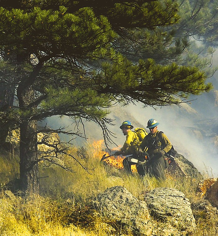 AP
Firefighters work above Boulder Canyon as trees catch fire near Boulder, Colo., on Friday. 