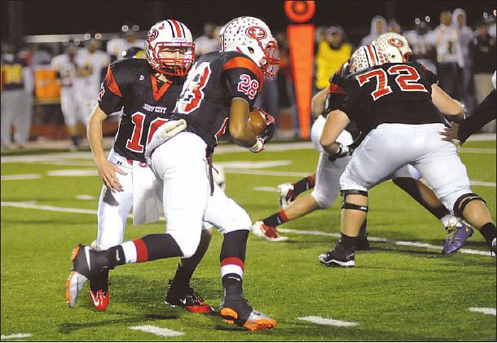 Jefferson City's Thomas LePage hands off to Devon Moore in Friday's game with Hickman at Adkins Stadium. To view this and other photographs, please visit www.newstribune.com/photos. 