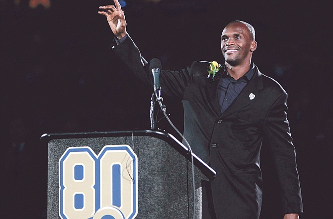 Former Rams receiver Isaac Bruce waves to the crowd during a ceremony to retire his number prior to Sunday's game with the Panthers in St. Louis.

