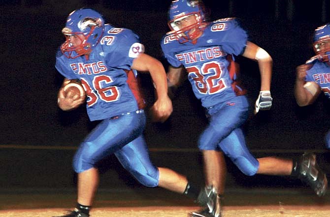 California's Brad Fairchild (36) scores an 85-yard touchdown in the first quarter of the Pintos' district game Friday. Providing coverage is Adam Burger (82).
