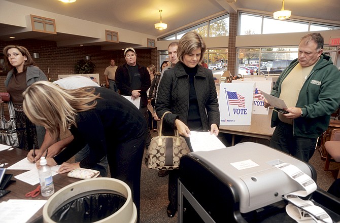 Voters wait to place completed ballots into an optical scanning machine Tuesday at Trinity Lutheran Church on Swifts Highway. Poll worker Ginny Engelbrecht said the precinct experienced a heavy turnout. 