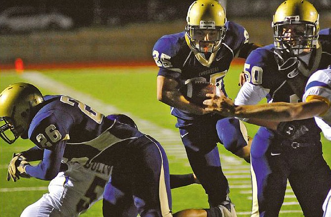 Helias' Greg Lorang finds a hole between his blockers during a touchdown run against Bolivar on Thursday at Adkins Stadium. Lorang and the Crusaders will host Carthage in a Class 4 Regional game tonight. 