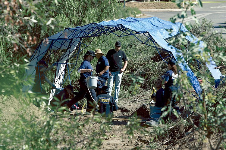Authorities work to uncover human remains in a canyon Thursday in Santa Clarita, Calif. Bones and clothing found Wednesday were believed to be the remains of Lynsie Ekelund, a 20-year-old Fullerton College student who has been missing since 2001. 