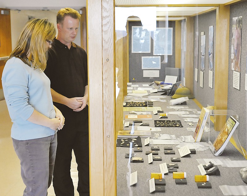 Charles Machon, of the Missouri Military Museum, and Missouri National Guard archaeologist Regina Meyer look at the newly prepared display of items from the dig in September now on display in the National Guard Headquarters building. 