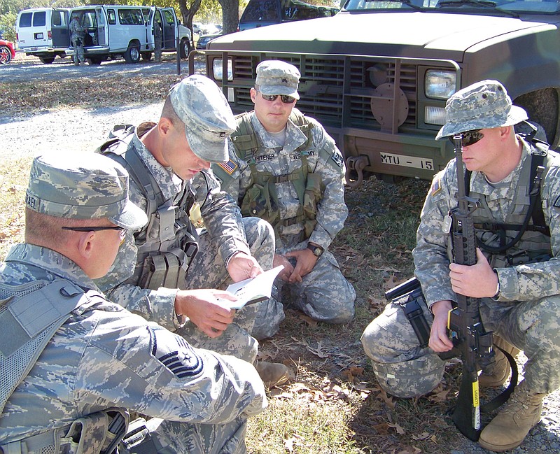 Master Sgt. Benjamin Israel, of Mount Moria; Staff Sgt. James Phelps, of Jefferson City; Sgt. James Whitener, of Perryville; and Sgt. Ryan Liggett, of Marshall, confer before a match at the Winston P. Wilson Marksmanship Sustainment Training Exercise. 