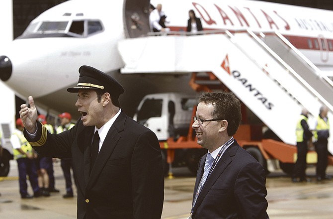 Hollywood actor John Travolta, left, gestures while standing next to Qantas CEO Alan Joyce, after his arrival in Sydney to participate in the 90-year anniversary of Qantas on Saturday. 