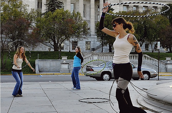 Hulagens Lisa Capestro, right, Lois Bennett, foreground, and Christa Jefferies, center, practice with their hula hoops on the northside of the Missouri Capitol. 