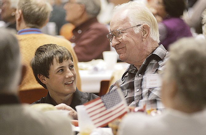 Jefferson City High School sophomore Colby Thompson talks with Korean War veteran Jesse Dillon during an appreciation dinner Wednesday evening in the JCHS cafeteria.

