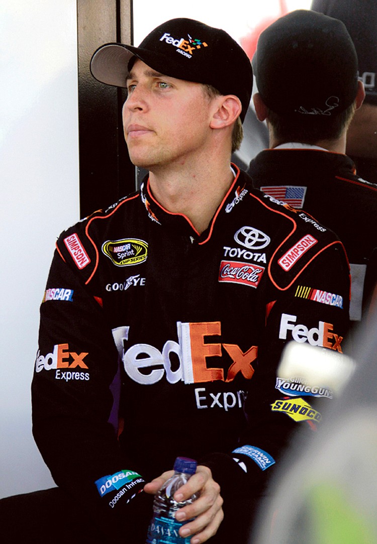 Driver Denny Hamlin sits in his garage during practice for Sunday's NASCAR Ford 400 auto race, Friday, Nov. 19, 2010, in Homestead, Fla.(AP Photo/Terry Renna)