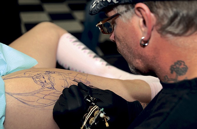 Jeff Roberts carefully inks the outline of a fairy onto Taniel Jones' right thigh Friday at Capital Tattoo Co. on High Street. Roberts has been a tattoo artist for 33 years, three years longer than the birthday Jones was commemorating. While tattoo parlors are now legal in Jefferson City, Mayor John Landwehr has asked the city council to investigate zoning the downtown area off-limits to future tattoo parlors. 