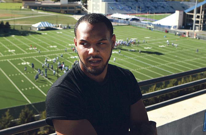 Kansas football player D.J. Marshall stands above the team's practice fields next to Memorial Stadium in Lawrence, Kan. Marshall was diagnosed a year ago this month with Hodgkin's lymphoma. After six months of treatment and a year of prayer, his recovery appears complete. 