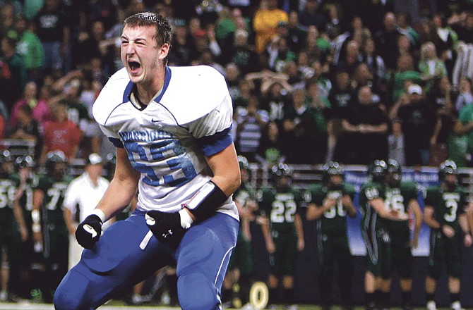 Valle Catholic's Brett Shuh tosses his helmet into the air in celebration after his team defeated Westran 22-21 in overtime to capture the Class 1 state football title Friday at the Edward Jones Dome. 