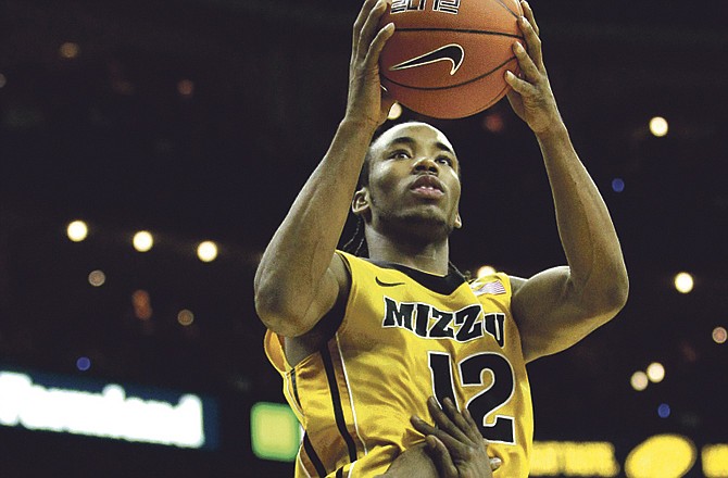 Missouri guard Marcus Denmon (12) puts up a shot during the first half of a game the Tigers lost to Georgetown on Tuesday in Kansas City, Mo. 