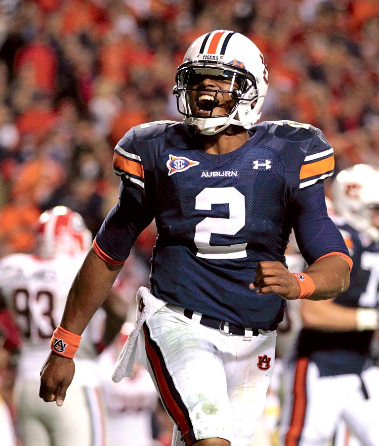 FILE - This Nov. 13, 2010, file photo shows Auburn's Cam Newton reacting following a second half Auburn score during a 49-31 win over Georgia in an NCAA college football game at Jordan-Hare Stadium in Auburn, Ala. Newton is eligible to play in the SEC title game, even though the NCAA says his father broke rules by shopping his son to another school. The NCAA released its finding in a statement on Wednesday, Dec. 1, 2010. (AP Photo/Dave Martin, File)