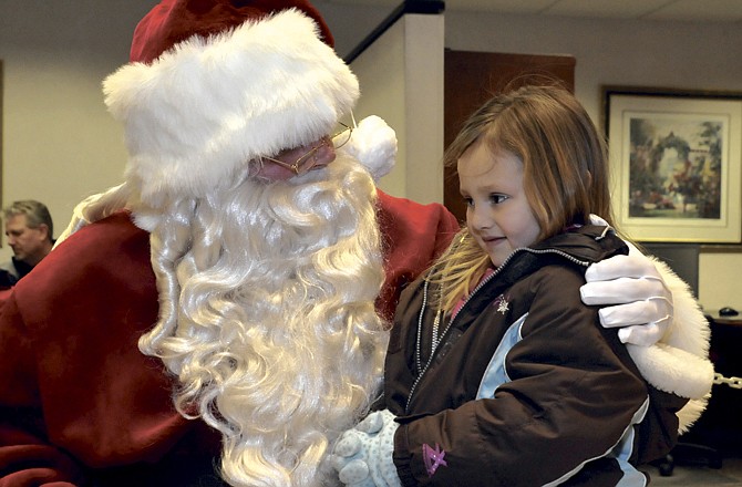 Sophia Abbott talks with Santa Friday in Hawthorn Bank during Living Windows. Many families celebrate their own traditions for the holiday. 