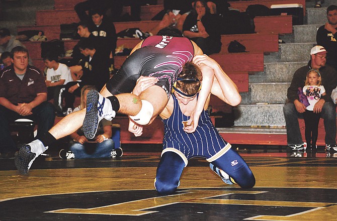 Logan Gaines of Helias gets Poplar Bluff's Ethan Swingle off the mat during their 135-pound match Saturday in the Kickoff Classic. 