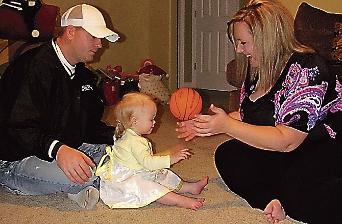 Shawn and Tracy Chilton play with their daughter, Zoe, in their Jefferson City home. The family survived carbon monoxide poisoning over the Thanksgiving holiday. 