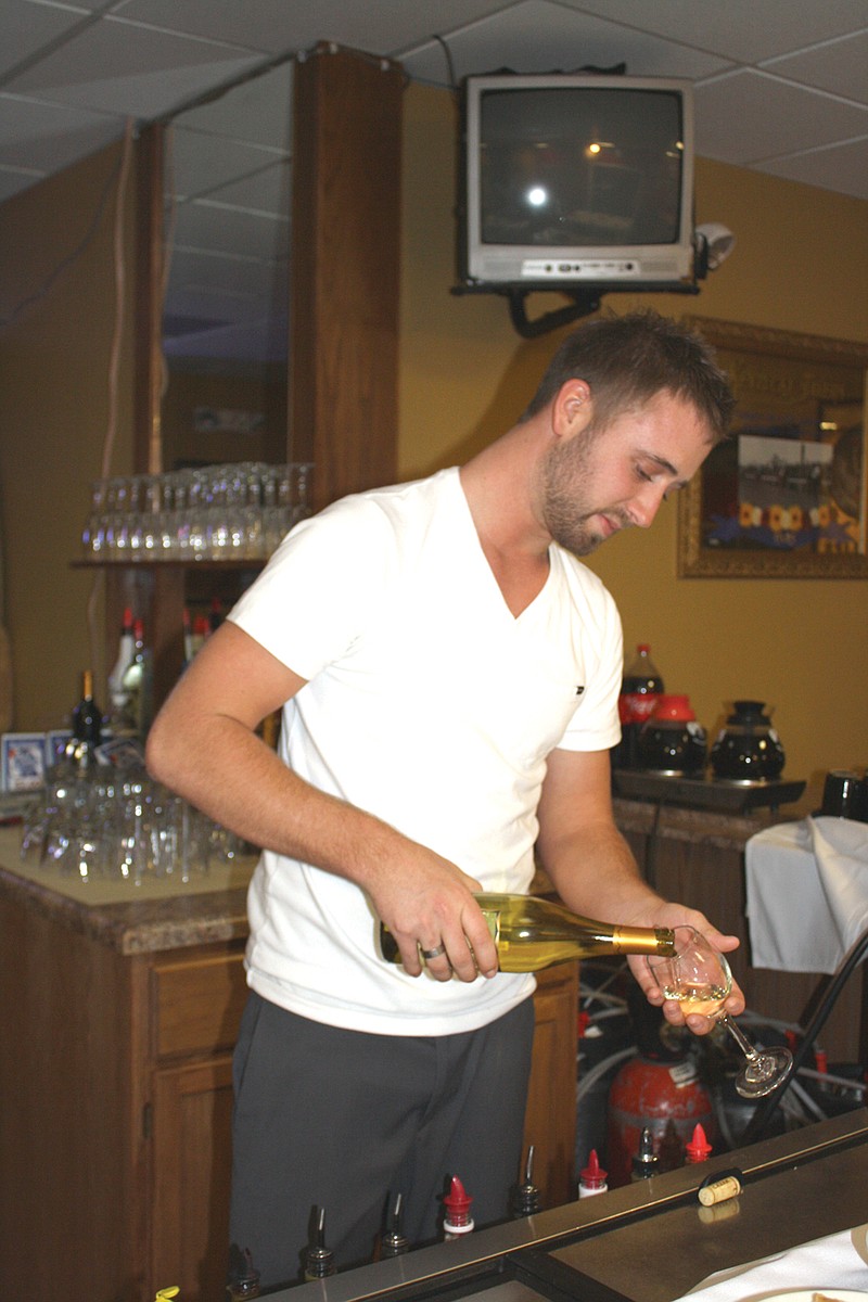 Mandi Steele/FULTON SUN photo: Bartender Chad Thompson pours a glass of wine at The 19th Hole, The Grill's new downstairs bar. The 19th Hole's grand opening Friday night features music by DJ Rice, drink specials and door prizes.