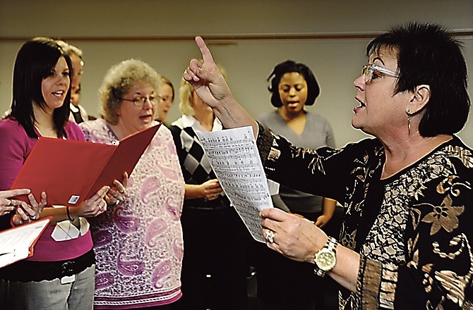 Employment Security Director Gracia Backer, right, leads the DES Christmas choir Thursday at the division's building on Dunklin Street. 