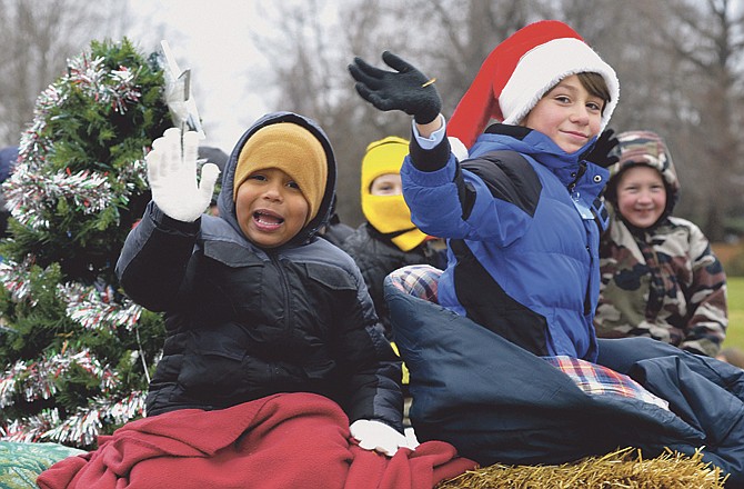 Cub Scouts from Pack 4 wave as they stay warm on one of the floats in the Holts Summit Parade on Saturday. 