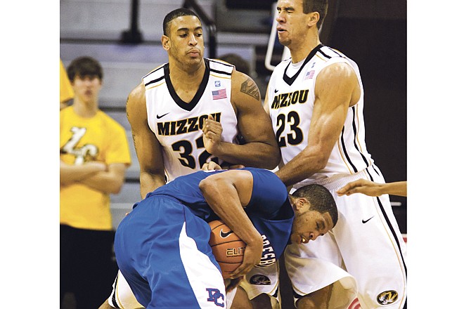 Presbyterian's Al'Lonzo Coleman runs into Missouri teammates Steve Moore (left) and Justin Safford while driving toward the basket during the first half of Saturday afternoon's game at Mizzou Arena. 