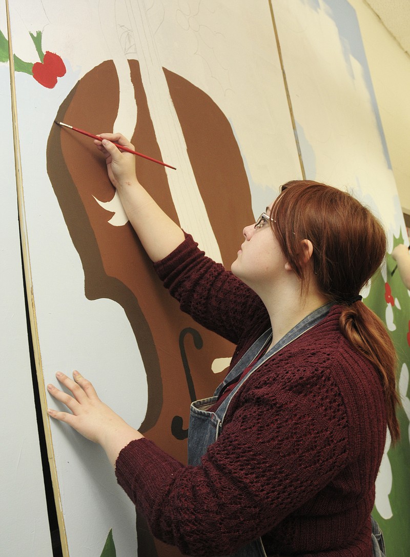 Julie Smith/News Tribune
Jefferson City High School art student Julia Elliott, a junior, has been working on the backdrop for this year's Capitol Caroling. She and fellow art students are painting holly leaves and berries with a large cello as the centerpiece. The 73rd Capitol Caroling will be held tonight at 7 in the Capitol Rotunda.