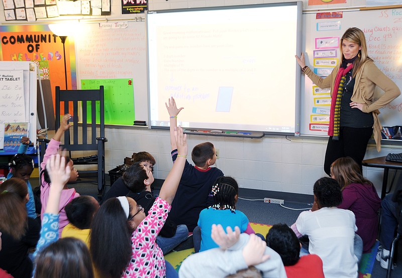 FILE: Fourth-graders wave their hands to answer a question from their teacher, Jada Salmons, right, during a 10-Minute Math problem at Lawson Elementary School.