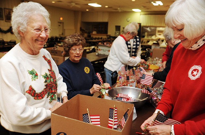 Alice DeWesplore, left, talks with Claudia Goodin as they and other members of the American Legion Auxiliary pack gift bags Friday morning at Post 5. Later Friday, they distributed more than 100 packages to veterans who live in area nursing homes. The project is funded in part by the auxiliary's annual poppy sale.