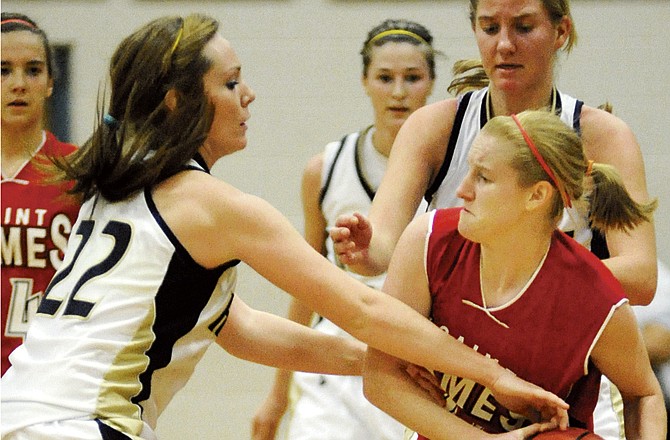 Arielle Chambers (22) of Helias and teammate Alex Heislen try to wrestle the ball from Amanda White of St. James during the second half of Saturday's game at Rackers Fieldhouse. 
