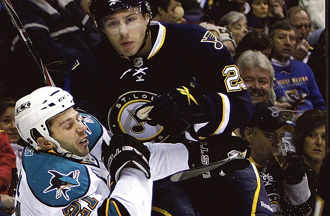 St. Louis Blues' Ian Cole, right, collides with San Jose Sharks' Scott Nichol along the boards during the first period of an NHL hockey game Saturday, Dec. 18, 2010, in St. Louis. 