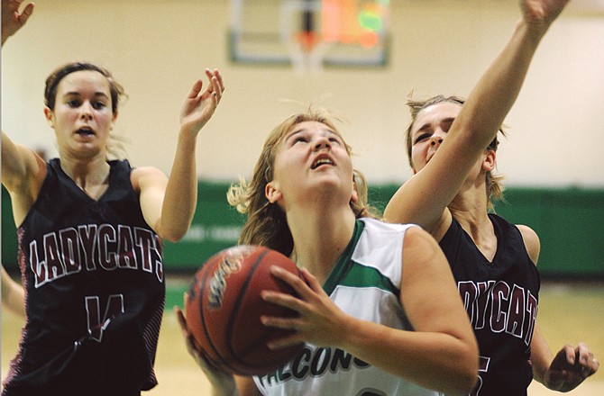 Linn teammates Brooke Foster (left) and Brittany Bexten (right) try to defend a putback by Amy Dorge of Blair Oaks during Monday night's game in Wardsville.