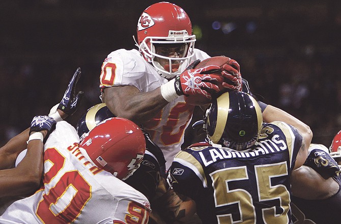 Kansas City Chiefs running back Thomas Jones, top, leaps over the pile to score on a two-yard touchdown-run as Chiefs' Shaun Smith (90) blocks and St. Louis Rams linebacker James Laurinaitis (55) defends during the fourth quarter Sunday in St. Louis. The Chiefs won 27-13.