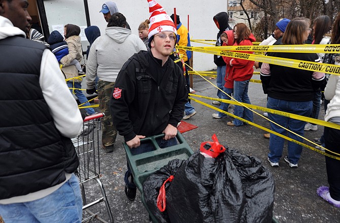 Jonathan Selvage hustles a shopping cart of toys out to a waiting car during distribution day Wednesday at the Salvation Army.  Jonathan is the son of Salvation Army Capts. Terry and Cheryl Selvage. 