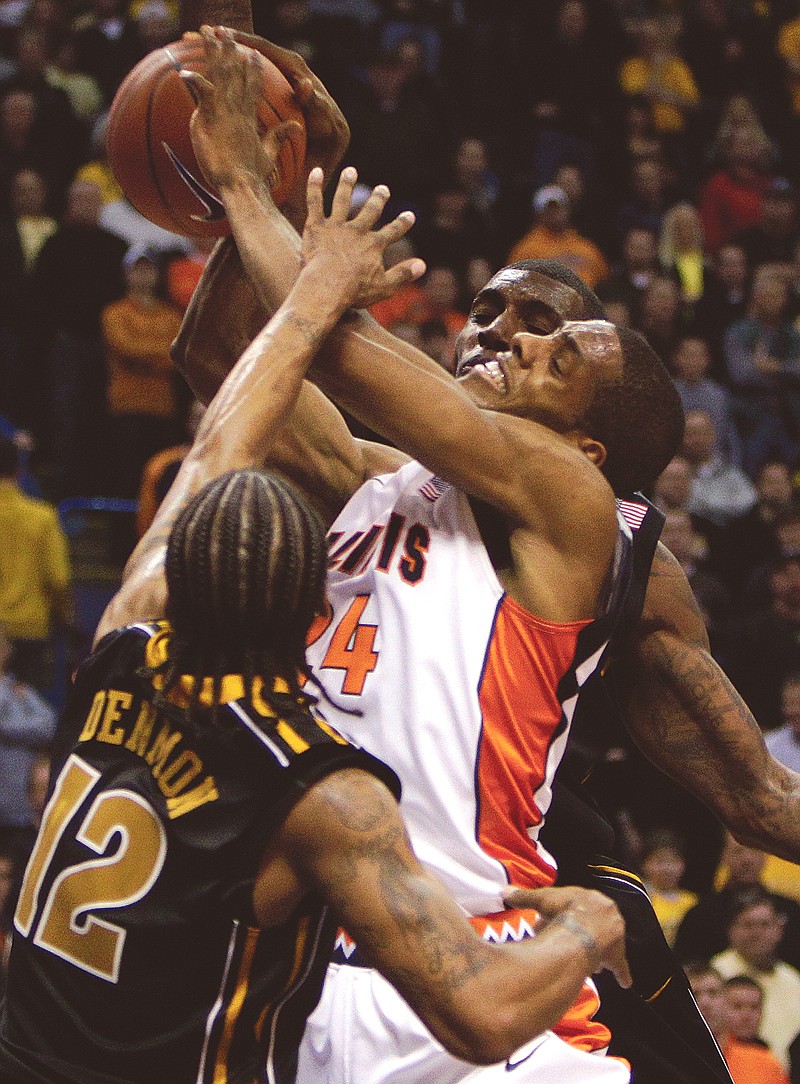 Illinois' Mike Davis (24) heads to the basket as Missouri's Marcus Denmon (12) and Ricardo Ratliffe, rear, defend during the second half of an NCAA college basketball game Wednesday, Dec. 22, 2010, in St. Louis. Missouri won 75-64. 