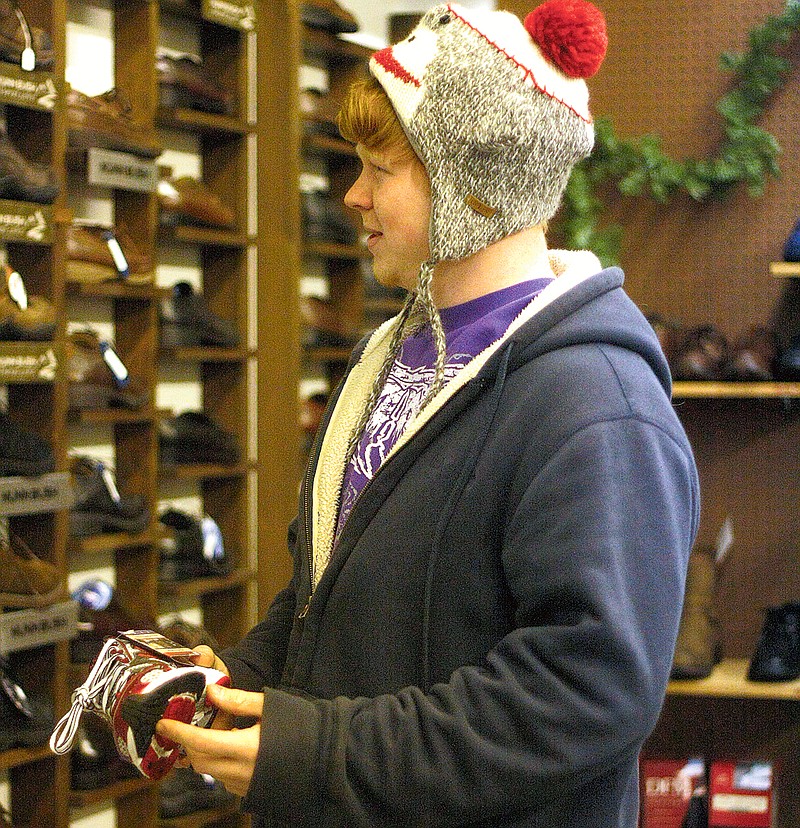 Stephanie Backus/FULTON SUN photo: Michael Clay, 18, of Fulton shopped for shoes on Tuesday at Gidley's Shoe Store in downtown Fulton. Downtown businesses said they saw a good turnout for local shopping during the holiday season. Many of the stores are currently holding their year-end sales.