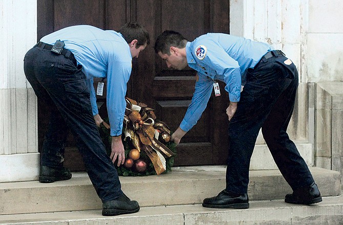 Fulton firefighters Michael Bainbridge and Daniel Berry lay a wreath on the steps of the Church of St. Mary the Virgin, Aldermanbury on Wednesday after bells rang in conjunction will bells at St. Paul's Cathedral in London to commemorate the 70th anniversary of the largest German air raid of World War II.