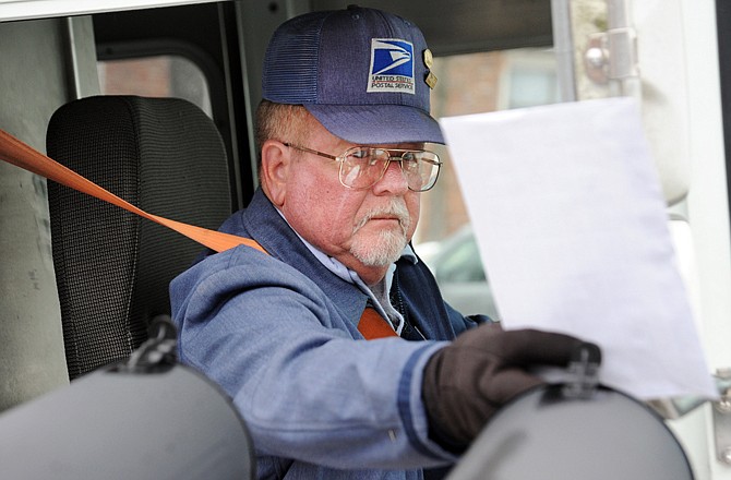 Terry Stone delivers the mail Wednesday at an apartment complex off Hutton Lane. Stone, one of the longest-serving postal carriers in Jefferson City, plans to retire at the end of the year to run his cattle farm in Centertown.