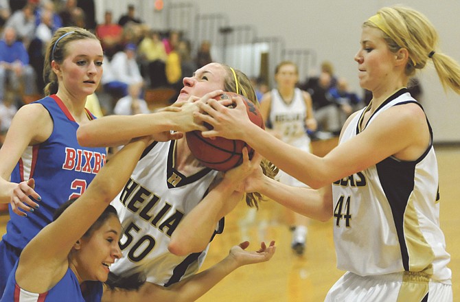 
Helias teammates Elizabeth Grothoff (50) and Emma Verslues (44) fight for a rebound during Tuesday's game against Bixby, Okla. 