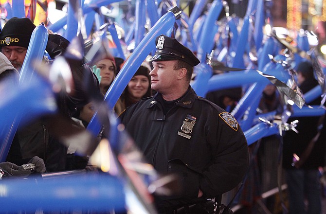 A New York City police officer keeps an eye on the crowd as 2009 New Year's Eve festivities begin on Times Square in New York. In the biggest public party in the country, nearly a million revelers will cram into the streets of Times Square to watch the ball drop on New Year's Eve.