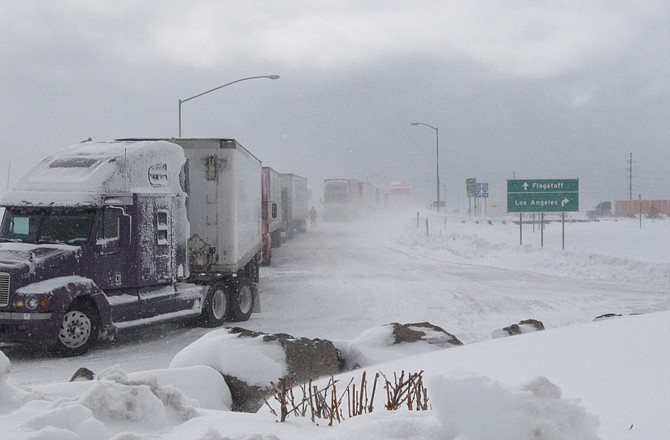 Semi-trucks line up over a bridge in Bellemont, Ariz., on Thursday. A winter storm kept motorists off Interstate 40 in northern Arizona for hours. 