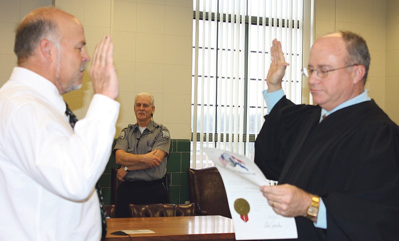 Don Norfleet/FULTON SUN photo: Gary Jungermann, left, takes the oath of office Thursday as the new Callaway County presiding commissioner from retiring Associate Circuit Judge Cary Augustine. 