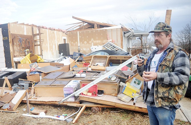Jerald Welch waits for his insurance agent to call after severe winds tore the roof off most of his house Friday near Rolla. Several homes and trailers in the neighborhood were damaged.