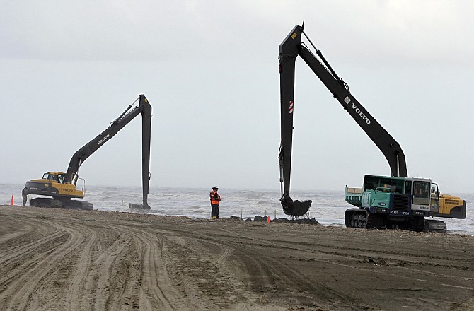 In this Dec. 16 photo, workers dig up sand impacted by the BP PLC oil spill on a beach on East Grand Terre Island on the coast of Louisiana. Crews have been scouring the Gulf Coast's sandy shores for oil digging, scraping, tilling and sifting beach after beach in their hunt. There is still an untold amount of oil in the form of gooey, largely non-toxic tar, lying under sand, mud and oyster shells along the shores, leaving the prospect that tar balls may wash up from time to time for months, if not years.
