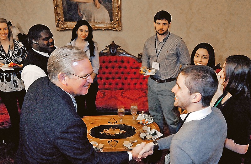 Weston Bland from Missouri State University shakes hands with Gov. Jay Nixon. Bland is one of a group of Missouri college campus leaders in Jefferson City to discuss challenges at the Governor's Faith and Leadership Forum.  
