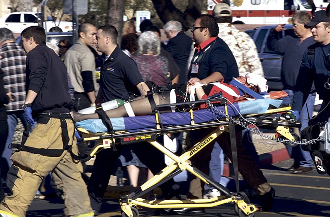Emergency personnel use a stretcher to carry a victim Saturday in Tucson, Ariz., after a shooting in which U.S. Rep. Gabrielle Giffords, D-Ariz., and others were shot as the congresswoman was meeting with constituents. 