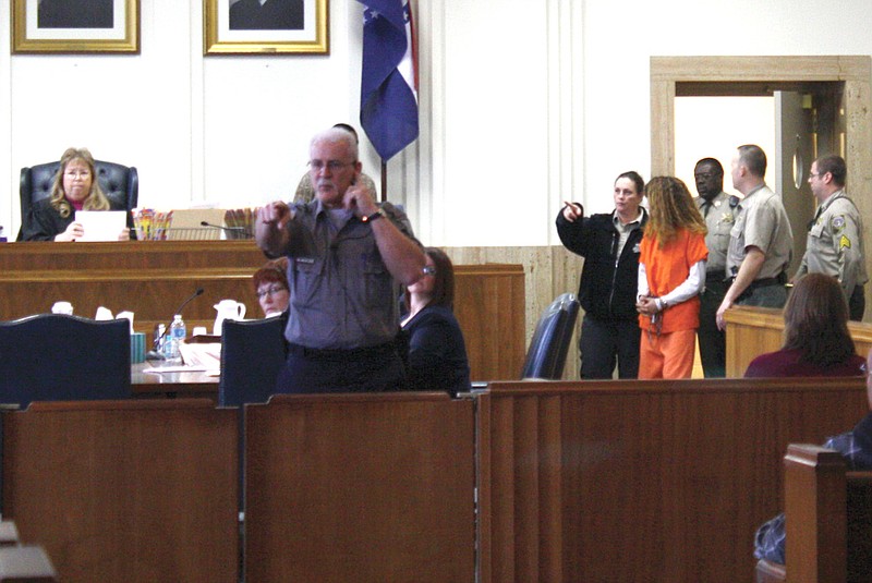 Mandi Steele/FULTON SUN photo: An officer in the Callaway County courtroom asks a bystander to put away his cell phone camera when Sandra Plunkett is brought out by officials Friday morning for her arraignment. Sandra is being charged with first-degree murder in the shooting of her husband, Paul Plunkett.